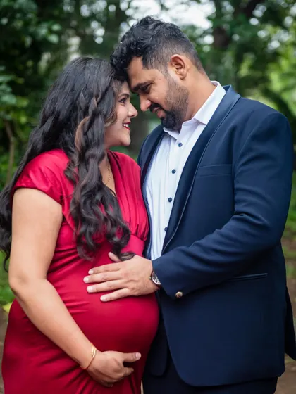 A close-up portrait that focuses on the intimate connection between the couple. The way they look at each other, with his hand on her baby bump, tells a story of shared love and excitement.