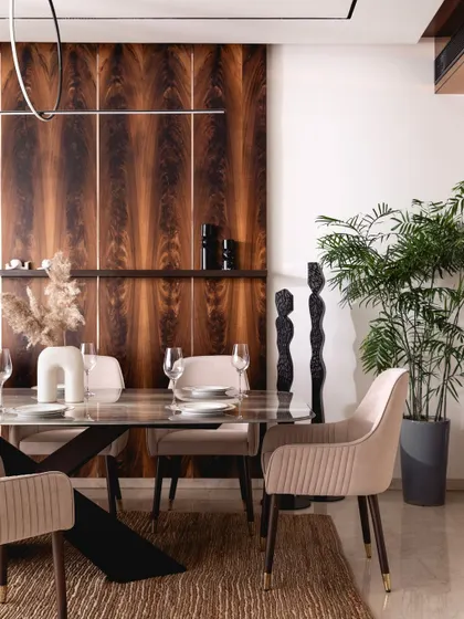 The rich grain of the mahogany panels provides a dramatic backdrop for the dining set. We used these panels to add character and define the common areas, much like a dash of cinnamon in a cappuccino.