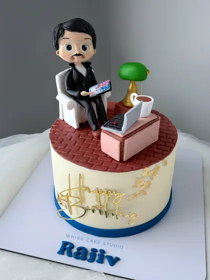 A cake for the man of the house. This design features a personalized figurine of a dad relaxing in his chair with his laptop and a cup of coffee.