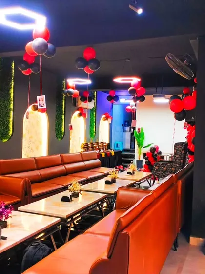 Another angle of the red and black themed party setup, showing the full length of the restaurant and how the decorations fill the space.