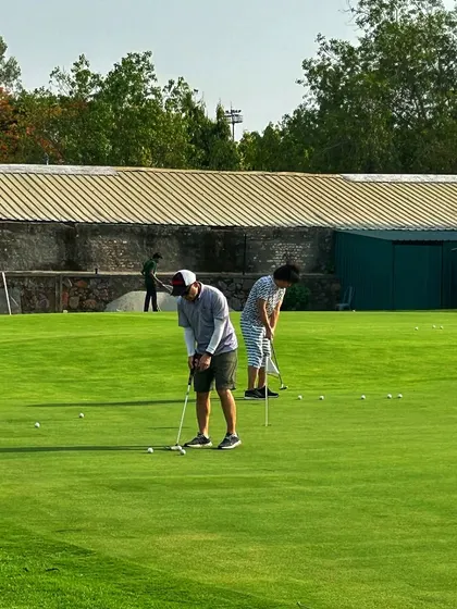 Two golfers work on their putting strokes on our expansive green.
