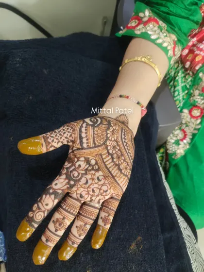 A beautiful example of a full-palm design with solid fingertips. The intricate paisley and floral work is a timeless choice for any wedding guest.