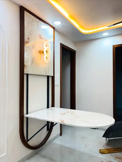 Here is a perfect example of my space-saving solutions for Mumbai homes. This wall-mounted dining table folds away neatly, transforming into a decorative wall panel with an accent light, making it ideal for compact living areas.