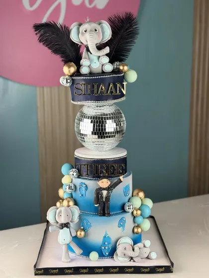 Standing tall and majestic. This elephant-themed cake is a sweet celebration of grandeur, featuring a disco ball tier and adorable fondant elephants for a unique birthday party.