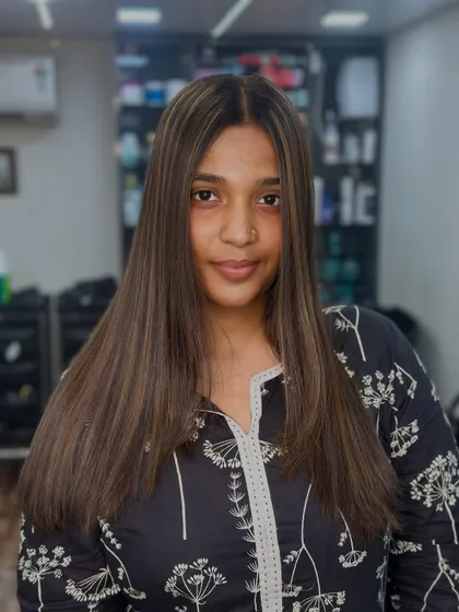 A beautiful, confident client showing off her fresh, straight hair with perfectly blended highlights. The art of the highlight is in the details.