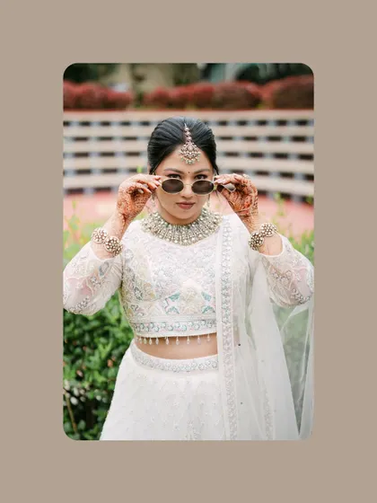 A fun and stylish portrait of the bride putting on sunglasses over her traditional attire. This shot shows her playful side and modern attitude.