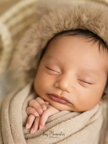 Another beautiful close-up, showcasing the baby's serene expression and tiny hands tucked under their chin. This pose emphasizes their delicate and peaceful nature.