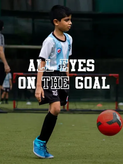 A young player focused on the ball, demonstrating the concentration I instill in all my athletes. It's all about keeping your eyes on the goal.