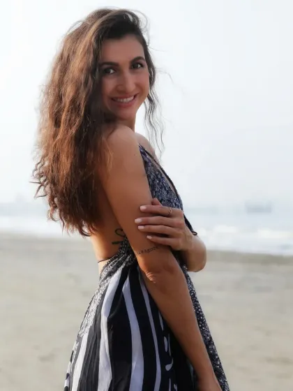 A warm and friendly portrait with a genuine smile. The natural beach setting and soft light make this image feel authentic and approachable.