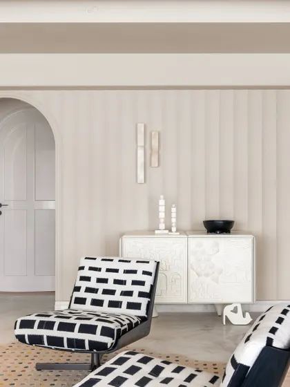 A detail of the living area, where black and white patterned chairs add a graphic punch to the otherwise subdued and calming palette.