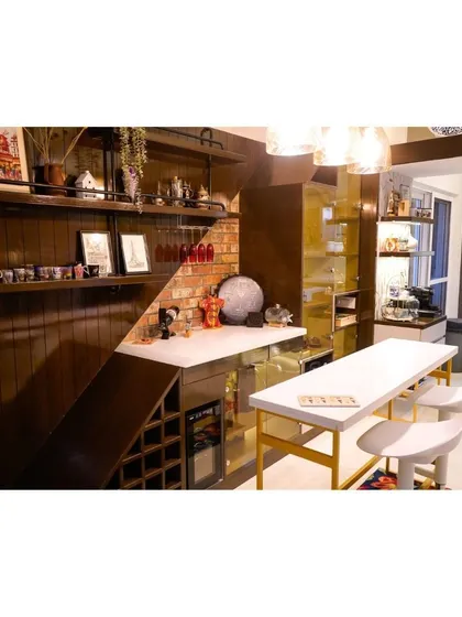 This bespoke indoor bar and pantry unit is the ultimate in home organization and entertainment. Tucked neatly under the stairs, it features a brick-textured backsplash, open shelving for decor, and a dedicated wine fridge, making brilliant use of space.