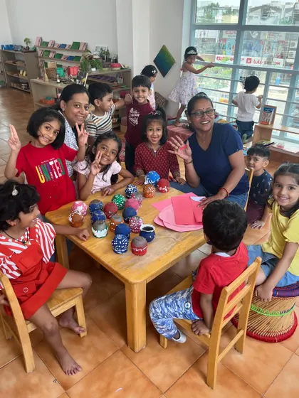 A happy group of children shows off their decorated cup creations. Collaborative art projects are a great way to build community and share ideas.