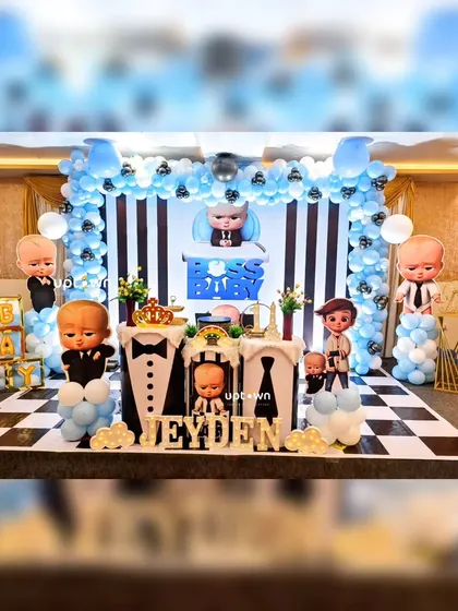A fun and stylish Boss Baby themed birthday party with a checkerboard floor and character cutouts.