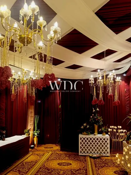 A view of the hall, decorated with rich red drapes, grand chandeliers, and elegant candelabras, creating a spiritual and opulent atmosphere.