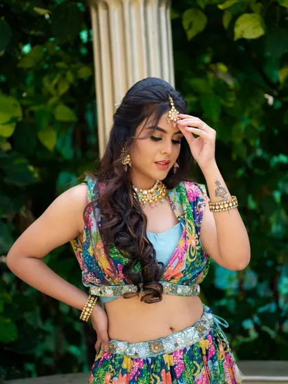 A classic portrait pose, adjusting her maang tikka. This is a timeless shot that feels both posed and natural, highlighting the beautiful details of her jewelry.