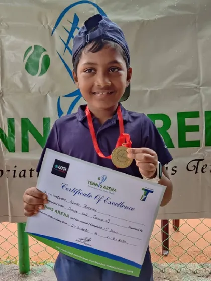 Every player is a winner here. This young athlete is all smiles with his medal and certificate after participating in our beginner's tennis tournament.