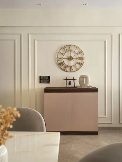This console unit, which also functions as a shoe rack, is placed at the entrance. Its clean lines, two-tone finish, and the elegant gold wall clock above create a stylish and functional first impression.