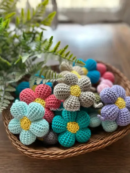 A basket full of our colorful crochet puff flower keychains. They can be used as bag charms or car charms too. We offer them in a wide range of colors to match any style.