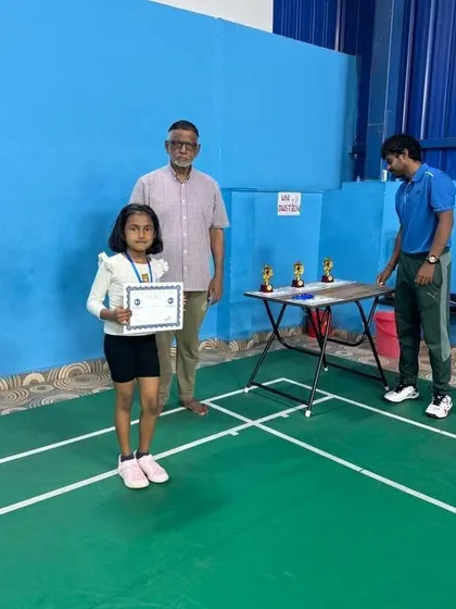 This student proudly displays her completion certificate after the tournament, a symbol of her dedication and progress during the camp.