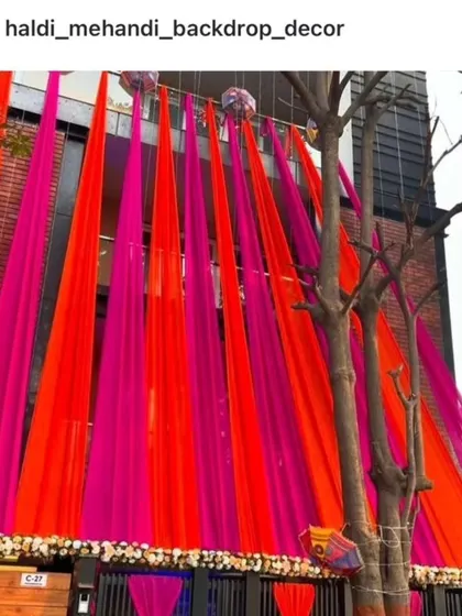 A bold and vibrant house front decoration with bright orange and pink drapes, perfect for making a statement.