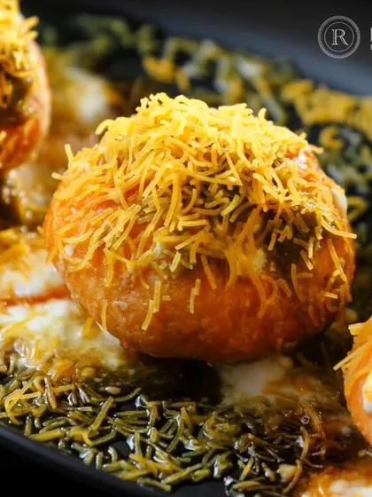 A close-up of our Raj Kachori, a classic Indian chaat. This "king of chaats" is filled with a delicious mix of sprouts, yogurt, and chutneys, and topped with crispy sev.