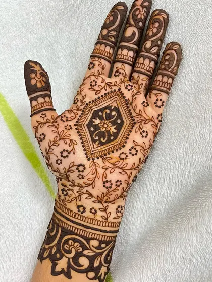A full view of the party henna design, showing the detailed finger work that complements the central pattern.