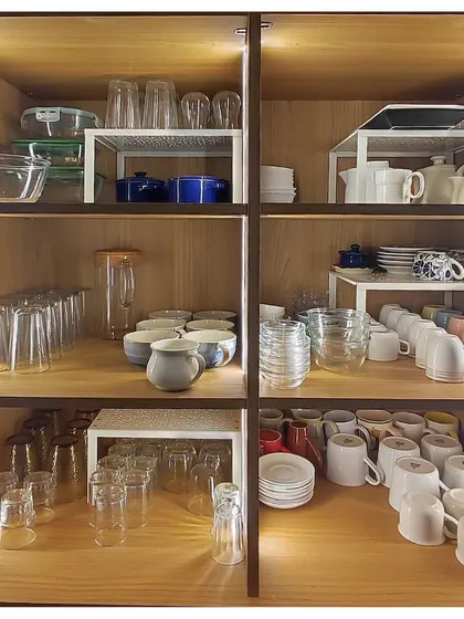 Using shelf risers is one of my favorite ways to maximize vertical space in a crockery cabinet. This simple tool instantly doubles your storage and makes every cup and plate easy to see and grab.