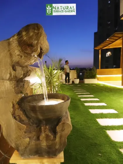 A unique rustic water feature installed at our Gwal Pahari project, crafted from natural wood to add a soothing, organic element to the garden.