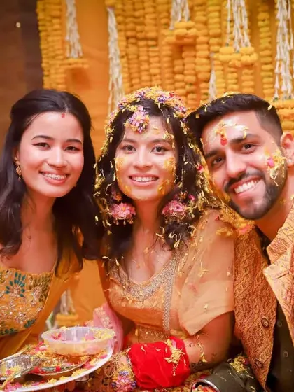 A happy group photo from the Haldi, with the bride, groom, and a sibling or friend smiling together. It’s a perfect snapshot of the celebration.