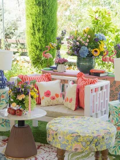 Another view of the whimsical lunch setup, with colorful printed cushions, fresh floral arrangements, and playful flamingo props.