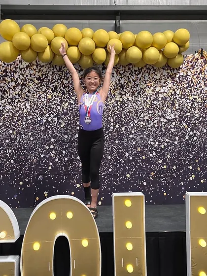Pure joy and a big medal! This gymnast celebrates her regional championship title.