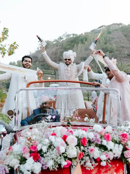 The groom and his squad celebrate with champagne poppers from a vintage car. We plan baraats that are personal, full of life, and incredibly fun.