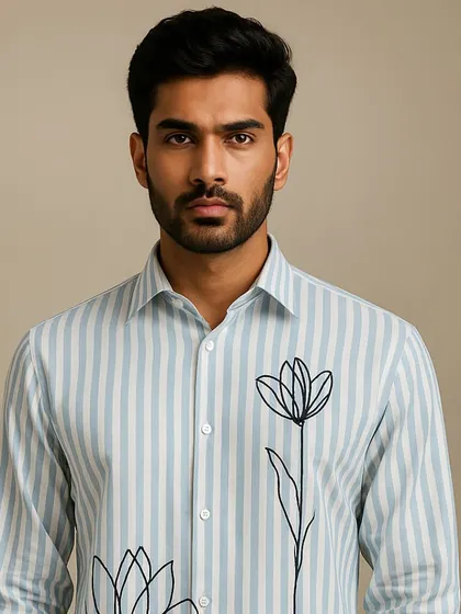 A portrait of the striped shirt with floral line art. The simplicity of the black embroidery against the patterned fabric creates a balanced and elegant design.