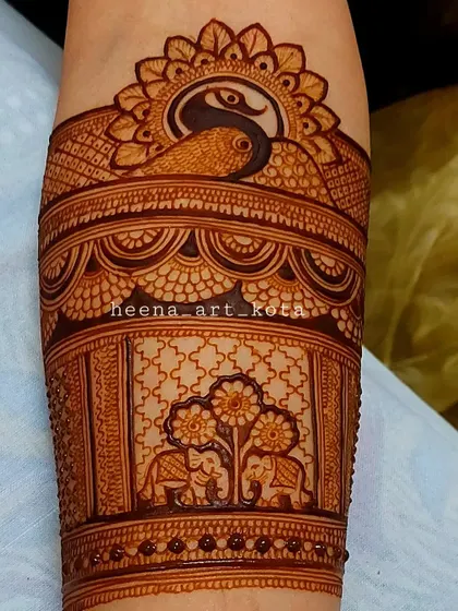 A detailed arm band featuring a peacock and elephants, classic elements of a traditional Rajasthani design.