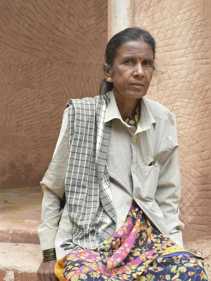 Portrait of Yentalakshmi, a fierce and bold mason on our team, sitting against a textured wall, showcasing the strength and determination she brings to every project.