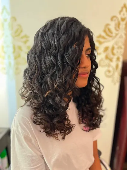 A side view showing the layers and movement in this long curly cut.