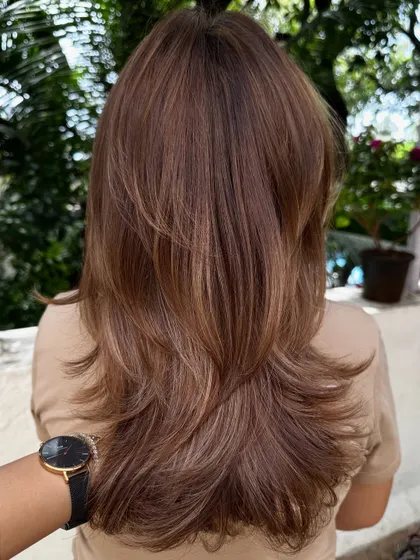 A beautiful example of a long layered cut, styled straight with a bit of volume. This is a timeless look that never goes out of style.