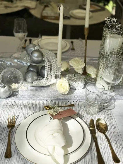 A perfectly set place at the luxe tablescape workshop, with gold-rimmed plates, gold cutlery, and a neatly folded napkin, showing attention to every single detail.