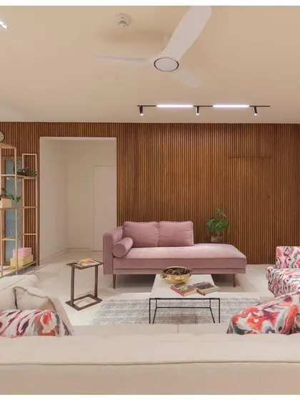 This perspective of the living room shows the sunken seating area and the interplay of different textures and colors. The design uses a metal partition to create a visual barrier to the dining area without closing off the space.