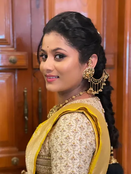 A stunning profile shot of this client. The makeup is classic and elegant, and her hair is styled in a beautiful traditional braid.