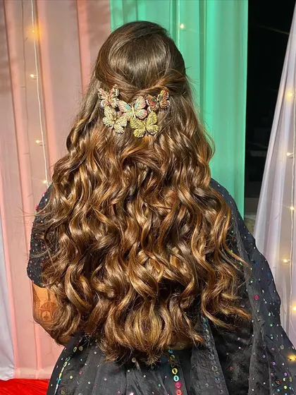 The hairstyle for this Rajasthani night look featured a cascade of soft curls, adorned with beautiful butterfly clips for a touch of whimsy.