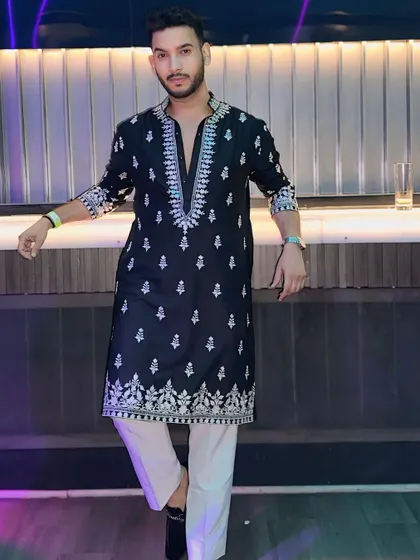 Leaning against the bar, this look is effortlessly cool. The detailed embroidery on the black kurta adds a touch of sophistication, making it suitable for both casual and formal events.