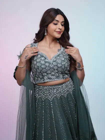 A different angle of the dark green lehenga, showing how the light catches the sequins. It's a sophisticated and glamorous choice.