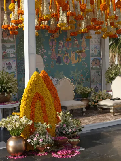 A wider view of the Pelikuthuru ceremony space, showing the floral cones, scattered petals, and the stunning hand-painted mural.