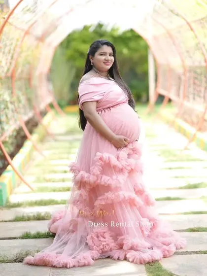 Our off-the-shoulder pink ruffled gown is a popular choice for its romantic and feminine style. It's perfect for capturing beautiful solo portraits that celebrate your pregnancy journey.