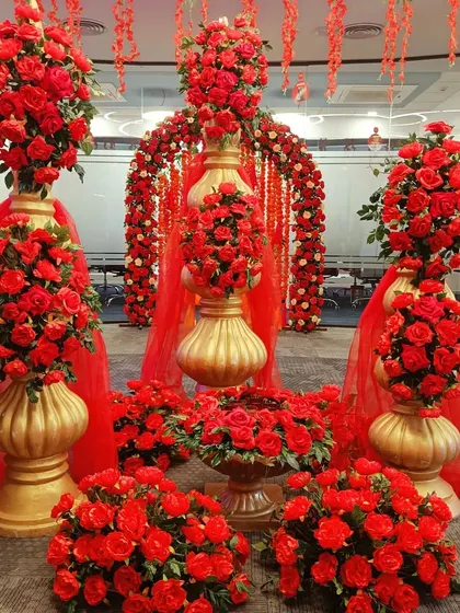 An explosion of red roses. This lavish arrangement, featuring large bouquets in golden urns and a floral arch, creates an atmosphere of pure romance and luxury.