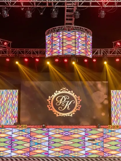 The stage is personalized with the couple's monogram on the LED screen, a detail that makes the grand setup feel intimate and unique to their story.