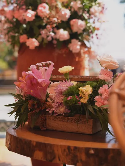 A charming floral arrangement in a rustic wooden box, adding a touch of country elegance to the outdoor setup.