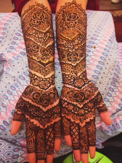A unique bridal design with chevron patterns on the arms, mixed with traditional rose motifs.
