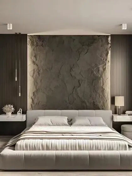 A minimalist bedroom design with a textured stone accent wall. The clean lines of the floating nightstands and the full-length mirror on the wardrobe create a sleek and modern look.